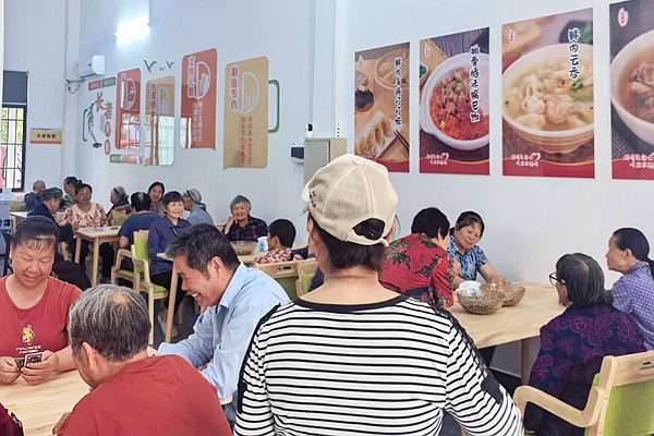 老人在社區(qū)愛心食堂體驗餐食。覃友麗攝