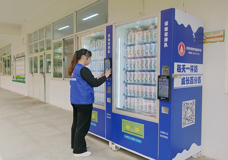 學(xué)生奶運營專員在檢查校園自助取奶機。何善權(quán)攝