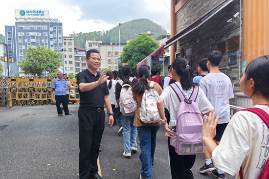 深圳市光明區(qū)教育幫扶團(tuán)隊(duì)領(lǐng)隊(duì)、田林縣初級(jí)中學(xué)校長(zhǎng)黃慶通目送孩子們放學(xué)。田林縣初級(jí)中學(xué)供圖
