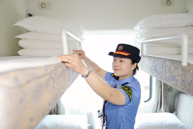 中越國際旅客列車列車長蘭秋霜整理臥鋪臥具。曹爍攝