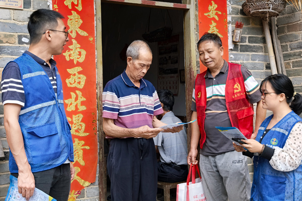 黨員志愿者和網(wǎng)格員向群眾宣傳防汛知識，提醒群眾做好防護(hù)。程豪輝攝