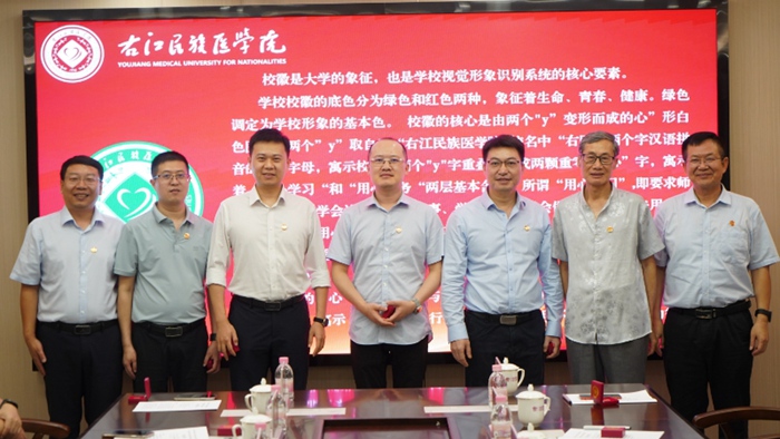 李雪斌、王俊利為杰出校友代表贈送并佩戴校徽。右江民族醫(yī)學院供圖