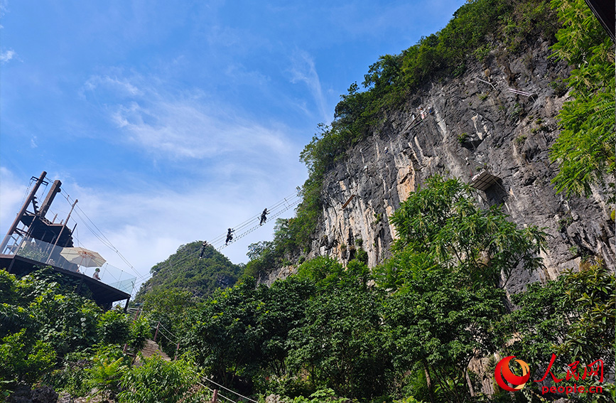 行進中國丨穿梭云端峭壁 解鎖桂林山水新視角當游客穿戴好安全設備，爬上通往懸崖峭壁的“天梯”，懸于山間，腳下是美麗的田園風光，清澈的小河蜿蜒流淌，遠處是連綿的山峰，共同構成了一幅生機勃勃的山水田園畫卷。