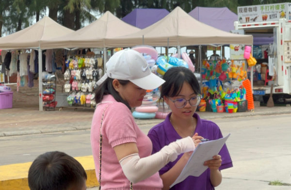 團(tuán)隊(duì)成員對(duì)游客進(jìn)行關(guān)于京族文化認(rèn)知程度與體驗(yàn)的問卷調(diào)研。廣西職業(yè)師范學(xué)院供圖