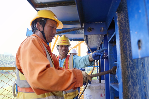 施工人員在那蒙澄碧河特大橋墩柱上進(jìn)行支模作業(yè)。呂松洋攝