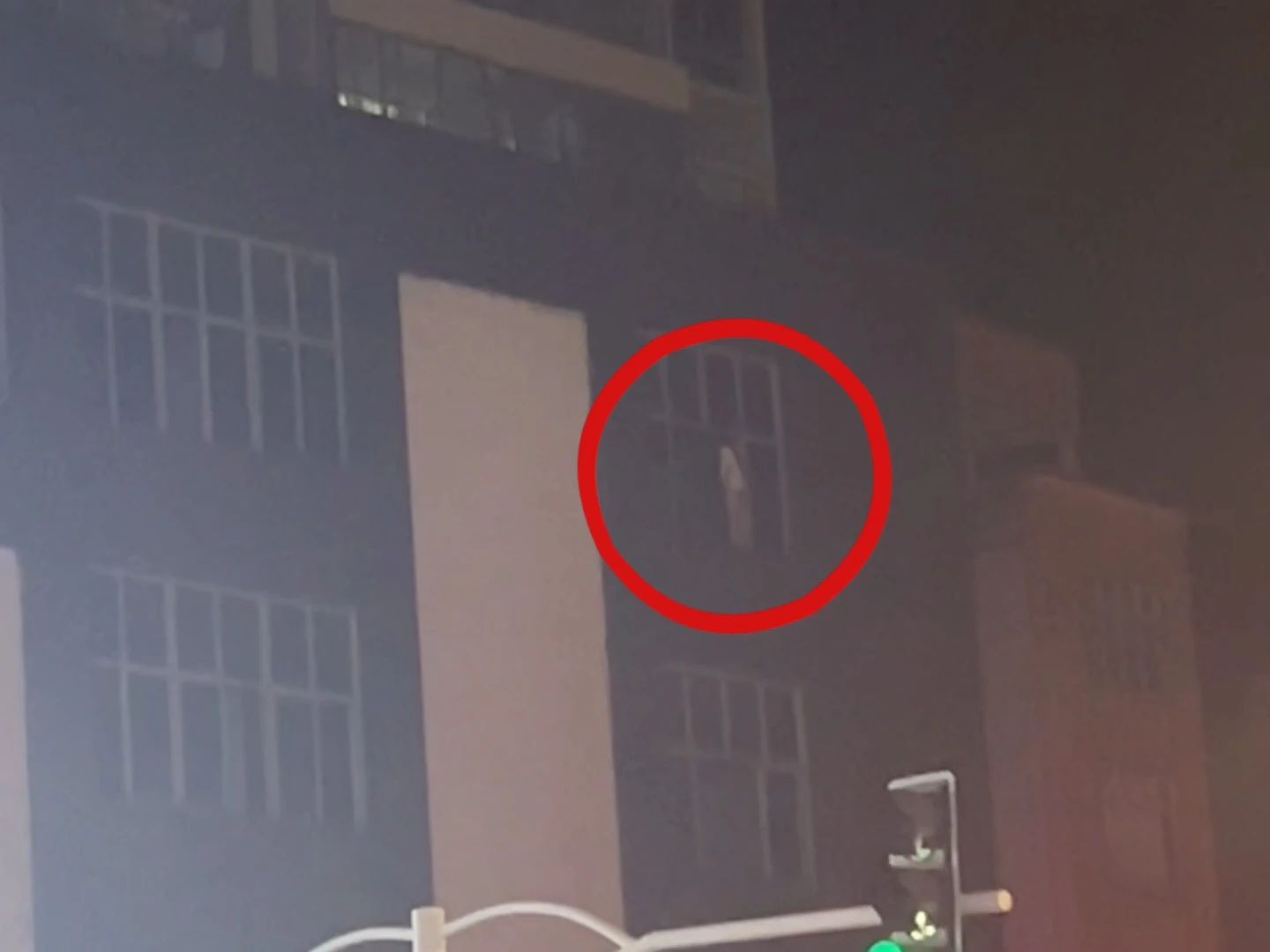 女子站在窗口，民警與其交談并耐心勸說(shuō)