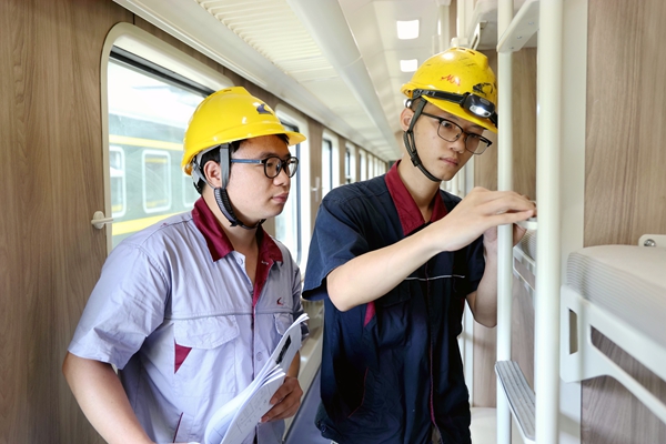 工作人員正在對(duì)普惠型適老化旅游列車(chē)臥鋪爬梯安裝狀態(tài)進(jìn)行檢查確認(rèn)。邢星攝