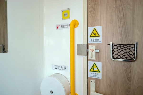 普惠型適老化旅游列車衛(wèi)生間內新增的緊急報警按鈕和L形扶手，還有加大加寬的提示標志。袁藝華攝