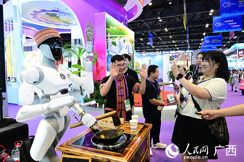 機器人在打油茶。人民網(wǎng) 雷琦竣攝