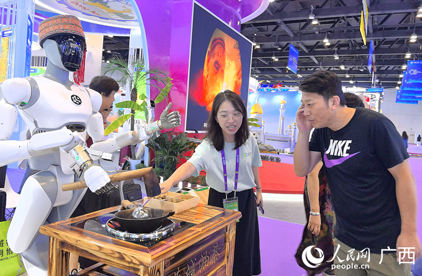 游客了解機(jī)器人打油茶。人民網(wǎng) 付華周攝