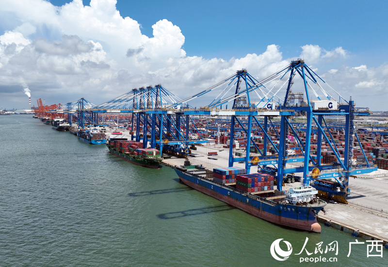 在廣西欽州北部灣港自動化集裝箱碼頭，貨輪在有序卸下集裝箱貨物。