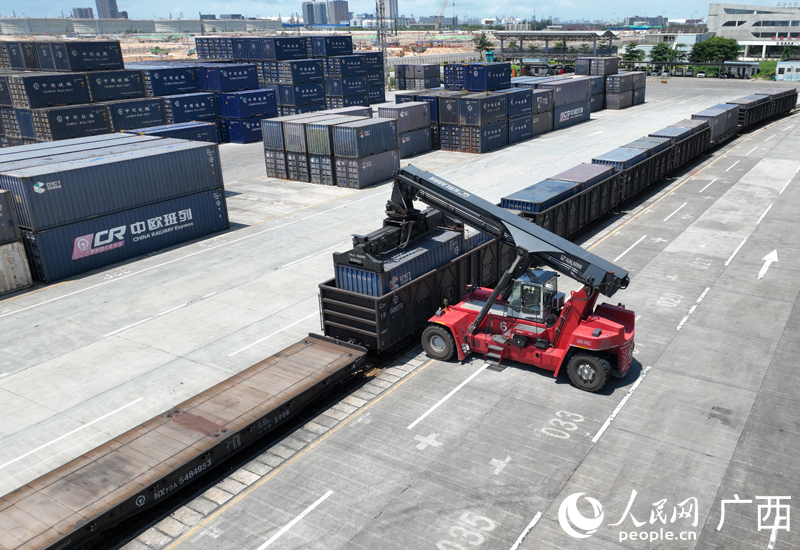 廣西欽州鐵路集裝箱中心站作業(yè)場內(nèi)，一臺正面吊正在吊裝集裝箱貨物。