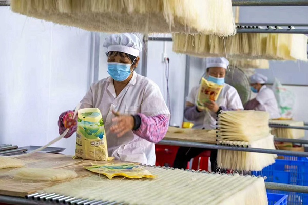 工人們正在對(duì)米粉進(jìn)行包裝