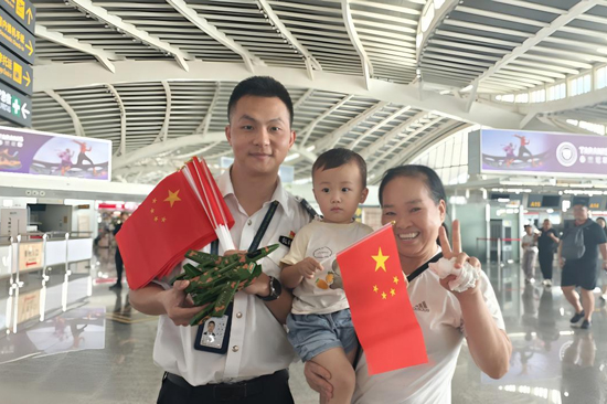 為旅客贈送手持國旗和小禮品。王劍攝