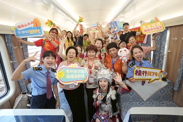 旅客與工作人員在“桂行天下號”普惠適老化旅游專列車廂里互動。蘭軻艨攝