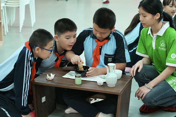 同學(xué)們手持茶筅攪動(dòng)茶碗，神情專(zhuān)注。馬金靜攝