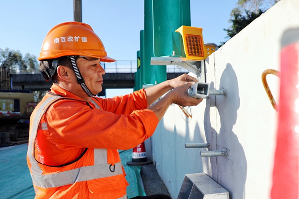 工人在安裝A級單側(cè)型施工區(qū)移動(dòng)護(hù)欄。黃園園攝