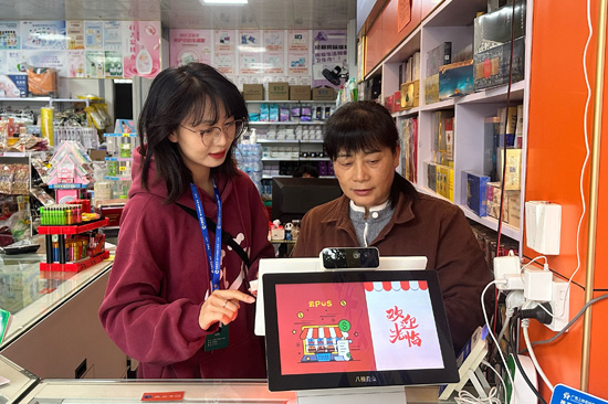 （客戶經(jīng)理指導(dǎo)零售戶使用終端系統(tǒng) 農(nóng)思彤 攝）