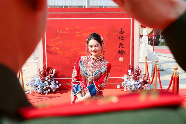 新郎向新娘敬軍禮。陳名利攝