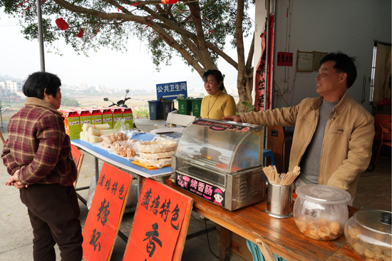 北寮嶺公園小賣鋪店主陳宗輝向游客介紹地方小吃
